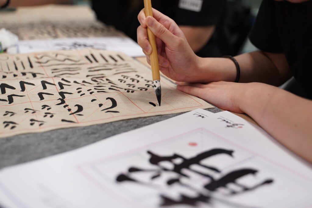 Some close ups of our SITizen practicing the strokes and dots of the Chinese characters.